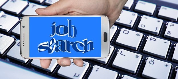 Says Job Search on a mobile phone in front of a computer keyboard